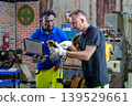 Diverse Team 20-40s Reviewing Robotic Controller Settings 139529661