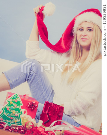 Woman wearing santa hat relaxing on sofa Woman wearing santa hat relaxing on sofa 139529951