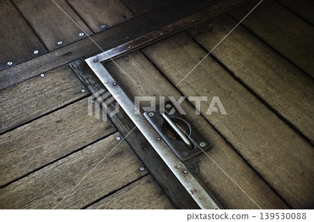 The weathered wooden floor and inspection hatch of the retro Showa-era diesel railcar Kiha 205. 139530088