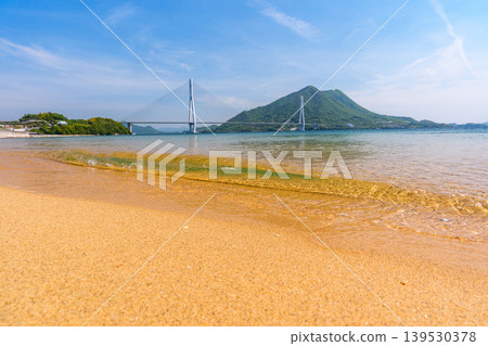 A stunning view of the Seto Inland Sea from the sandy beach of Omishima Island, overlooking the Tatara Bridge and Ikuchijima Island, along the Shimanami Kaido. A stunning view of the Seto Inland Sea from the sandy beach of Omishima Island, overlooking the Tatara Bridge and Ikuchijima Island, along the Shimanami Kaido. 139530378