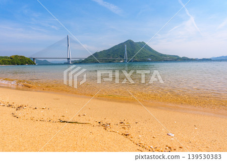 A stunning view of the Seto Inland Sea from the sandy beach of Omishima Island, overlooking the Tatara Bridge and Ikuchijima Island, along the Shimanami Kaido. 139530383