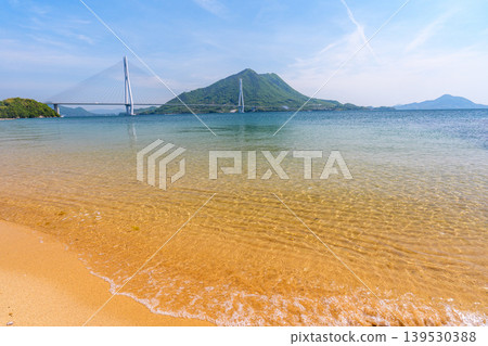 A stunning view of the Seto Inland Sea from the sandy beach of Omishima Island, overlooking the Tatara Bridge and Ikuchijima Island, along the Shimanami Kaido. A stunning view of the Seto Inland Sea from the sandy beach of Omishima Island, overlooking the Tatara Bridge and Ikuchijima Island, along the Shimanami Kaido. 139530388