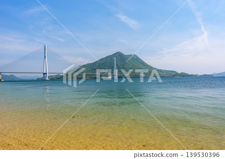 從大三島的沙灘上可以欣賞到瀨戶內海的壯麗景色,俯瞰著多多良橋和生口島,沿著島波海道而行。 從大三島的沙灘上可以欣賞到瀨戶內海的壯麗景色,俯瞰著多多良橋和生口島,沿著島波海道而行。 139530396