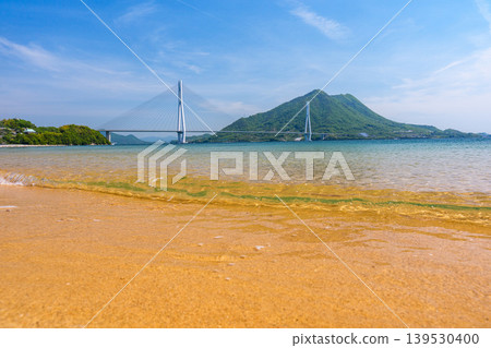 從大三島的沙灘上可以欣賞到瀨戶內海的壯麗景色,俯瞰著多多良橋和生口島,沿著島波海道而行。 從大三島的沙灘上可以欣賞到瀨戶內海的壯麗景色,俯瞰著多多良橋和生口島,沿著島波海道而行。 139530400