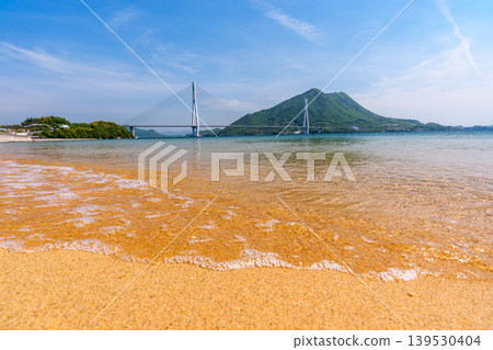 從大三島的沙灘上可以欣賞到瀨戶內海的壯麗景色,俯瞰著多多良橋和生口島,沿著島波海道而行。 從大三島的沙灘上可以欣賞到瀨戶內海的壯麗景色,俯瞰著多多良橋和生口島,沿著島波海道而行。 139530404