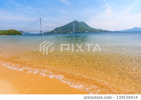 A stunning view of the Seto Inland Sea from the sandy beach of Omishima Island, overlooking the Tatara Bridge and Ikuchijima Island, along the Shimanami Kaido. A stunning view of the Seto Inland Sea from the sandy beach of Omishima Island, overlooking the Tatara Bridge and Ikuchijima Island, along the Shimanami Kaido. 139530414