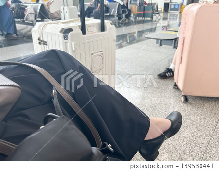 旅客們在機場候機室裡歇腳;行李箱和旅行用品整齊排列,構成了一個旅行的景象。 旅客們在機場候機室裡歇腳;行李箱和旅行用品整齊排列,構成了一個旅行的景象。 139530441