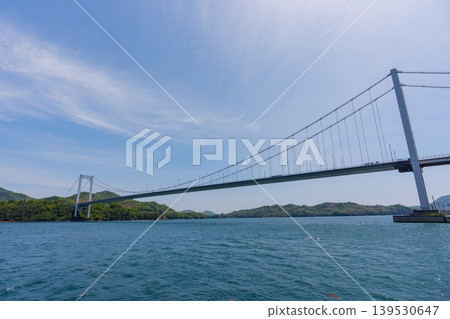 從愛媛郡今治市島波海道上的大島可以欣賞到博多大島大橋和瀨戶內海的壯麗景色。 從愛媛郡今治市島波海道上的大島可以欣賞到博多大島大橋和瀨戶內海的壯麗景色。 139530647
