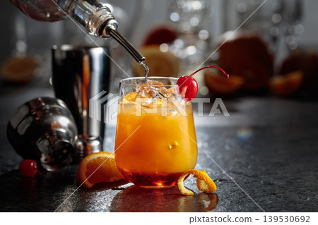 Making Tequila sunrise cocktail on a stone table in bar. Making Tequila sunrise cocktail on a stone table in bar. 139530692