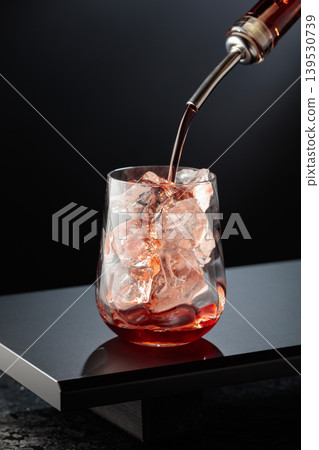 To make a Tequila Sunrise cocktail on a black table in bar. 139530739