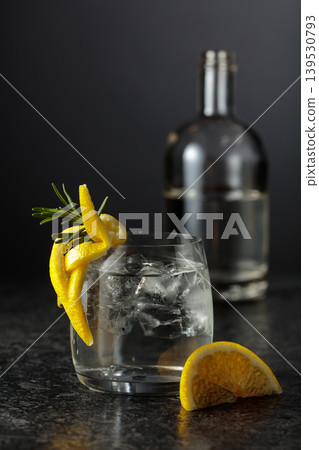 Gin and tonick cocktail in a fogged up glass on a black table. Gin and tonick cocktail in a fogged up glass on a black table. 139530793