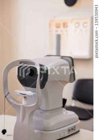 Eye Exam Machine in Doctor Office with Vision Chart Background for Medical Diagnosis Treatment Healthcare Concept Eye Exam Machine in Doctor Office with Vision Chart Background for Medical Diagnosis Treatment Healthcare Concept 139530943