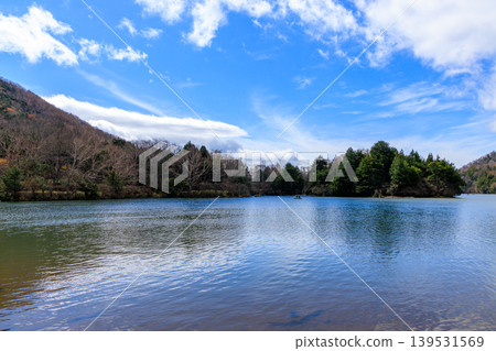 The beautiful Lake Yunoko in early spring and the blue sky reflected on its surface. The beautiful Lake Yunoko in early spring and the blue sky reflected on its surface. 139531569
