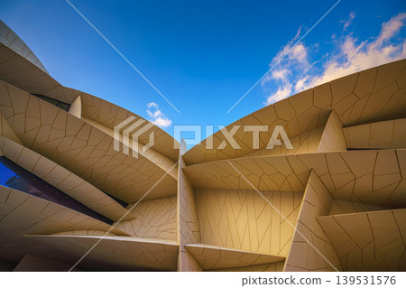 Doha, Qatar - Jan 06 2024, a panoramic view of National Museum of Qatar facade, exterior, shaped like a desert rose, at evening with blue sky, Doha, Qatar Doha, Qatar - Jan 06 2024, a panoramic view of National Museum of Qatar facade, exterior, shaped like a desert rose, at evening with blue sky, Doha, Qatar 139531576