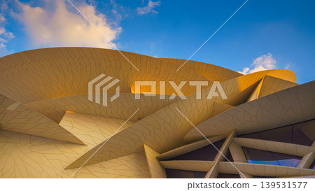 Doha, Qatar - Jan 06 2024, a panoramic view of National Museum of Qatar facade, exterior, shaped like a desert rose, at evening with blue sky, Doha, Qatar Doha, Qatar - Jan 06 2024, a panoramic view of National Museum of Qatar facade, exterior, shaped like a desert rose, at evening with blue sky, Doha, Qatar 139531577