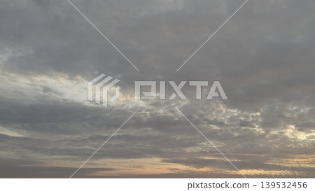 Soft grey clouds fill the dawn sky, warm light glows at the horizon. This natural atmospheric scene captures quiet weather transitions, moody morning textures, scenic outdoor views at dawn Soft grey clouds fill the dawn sky, warm light glows at the horizon. This natural atmospheric scene captures quiet weather transitions, moody morning textures, scenic outdoor views at dawn 139532456