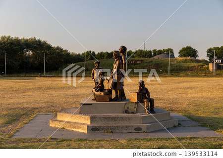 Rotterdam, South Holland, Netherlands - 09.06.2025: Bronze Kindertransport monument depicting refugee children with suitcases in Hook of Holland. Moving historical memorial at sunset with Fort 1881 Rotterdam, South Holland, Netherlands - 09.06.2025: Bronze Kindertransport monument depicting refugee children with suitcases in Hook of Holland. Moving historical memorial at sunset with Fort 1881 139533114