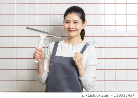 A woman cleaning with a smile - Housekeeping image A woman cleaning with a smile - Housekeeping image 139533484