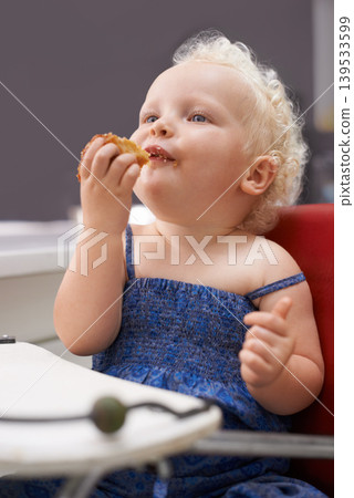 Kid, high chair and eating cupcake, food and breakfast sweets at home in kitchen. Young child, hungry toddler and muffin dessert, sugar and pastry snack for cute adorable girl in house in the morning Kid, high chair and eating cupcake, food and breakfast sweets at home in kitchen. Young child, hungry toddler and muffin dessert, sugar and pastry snack for cute adorable girl in house in the morning 139533599