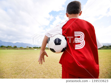 Child, back view and soccer player on field for practice, workout and ready for training on grass. Boy, athlete and ball for exercising and skill development, fitness and wellness or sports and match Child, back view and soccer player on field for practice, workout and ready for training on grass. Boy, athlete and ball for exercising and skill development, fitness and wellness or sports and match 139533623