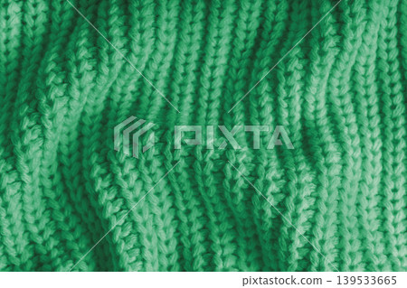 Crumpled green knitted fabric texture with folds, wrinkles and soft waves, wool background Crumpled green knitted fabric texture with folds, wrinkles and soft waves, wool background 139533665