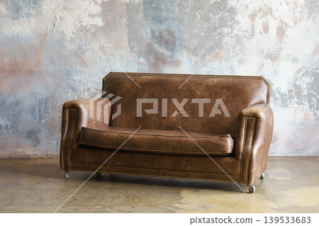 Brown vintage leather sofa, couch in loft interior on textured stucco, plaster wall background Brown vintage leather sofa, couch in loft interior on textured stucco, plaster wall background 139533683