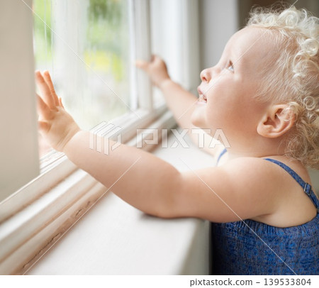 Happy, window and toddler with smile standing against glass or wall in family home learning to walk. Girl, female baby and young cute kid at house with childhood development or natural growth alone 139533804