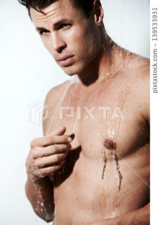 Serious man in shower to relax, cleaning and body hygiene for morning skin wellness routine. Grooming, skincare and face of male model with muscle washing with water, self care and calm in bathroom. Serious man in shower to relax, cleaning and body hygiene for morning skin wellness routine. Grooming, skincare and face of male model with muscle washing with water, self care and calm in bathroom. 139533931