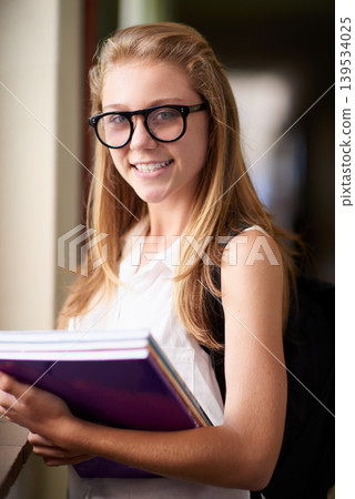 Happy woman, portrait and student nerd with books at school hallway for education, study or learning. Young female person, teenager or geek smile with glasses and textbooks for knowledge in corridor Happy woman, portrait and student nerd with books at school hallway for education, study or learning. Young female person, teenager or geek smile with glasses and textbooks for knowledge in corridor 139534025
