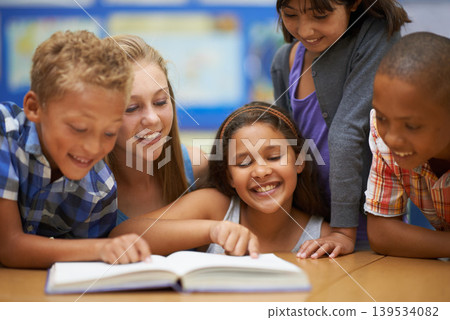 Children, teacher and reading a book in classroom for knowledge, learning or education with happiness. Group, student and woman at school with study, textbook and smile with diversity at college 139534082