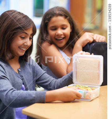 Happy girl, friends and student with lunchbox for eating meal, break or snack time in classroom at school. Young kids or elementary children smile for container, food or fiber and nutrition in recess 139534289