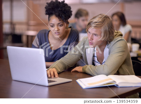 University, students and people in library on laptop for online research, studying and learning. Education, college and man and woman with textbooks, computer and reading website for knowledge University, students and people in library on laptop for online research, studying and learning. Education, college and man and woman with textbooks, computer and reading website for knowledge 139534359
