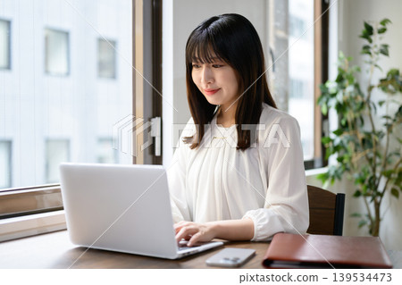在辦公室使用筆記型電腦的年輕女商人 139534473