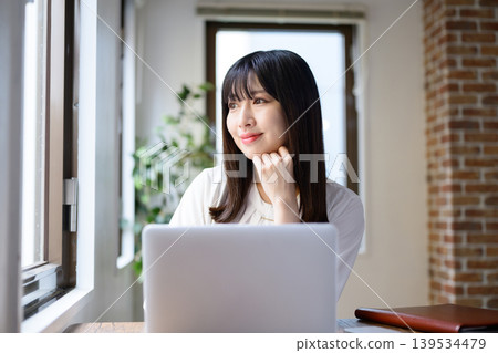 在辦公室使用筆記型電腦的年輕女商人 在辦公室使用筆記型電腦的年輕女商人 139534479
