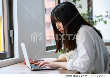 一位日本女性在辦公室裡看著筆記型電腦,陷入沉思。 一位日本女性在辦公室裡看著筆記型電腦,陷入沉思。 139534480
