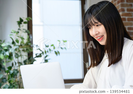 在辦公室使用筆記型電腦的年輕女商人 在辦公室使用筆記型電腦的年輕女商人 139534481