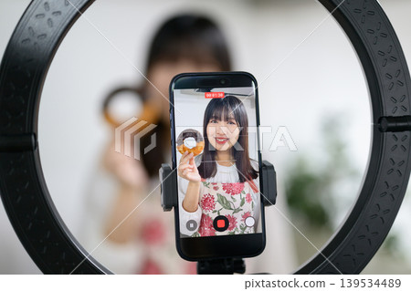 Japanese woman taking photos of sweets with her smartphone Japanese woman taking photos of sweets with her smartphone 139534489