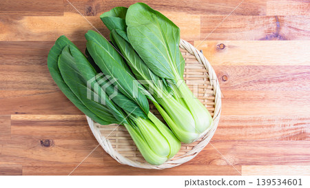 Bok choy, fresh bok choy on a basket, wooden table Bok choy, fresh bok choy on a basket, wooden table 139534601