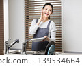 A woman washing dishes with a smile - an image of housework and daily life. 139534664
