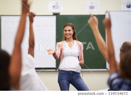 Teacher, hands and kids in classroom with question, learning and discussion for education or why. Woman, school children and happy with studying, knowledge and raised hand for scholarship or lesson Teacher, hands and kids in classroom with question, learning and discussion for education or why. Woman, school children and happy with studying, knowledge and raised hand for scholarship or lesson 139534672