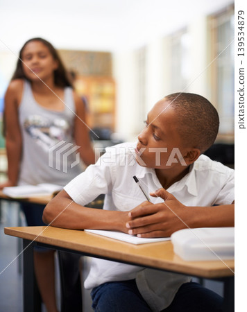 University, copy or students cheating in exam with paper, school corruption or education fraud. Cover, girl peeking or smart male child learner hiding or writing answers in test in classroom at desk University, copy or students cheating in exam with paper, school corruption or education fraud. Cover, girl peeking or smart male child learner hiding or writing answers in test in classroom at desk 139534879