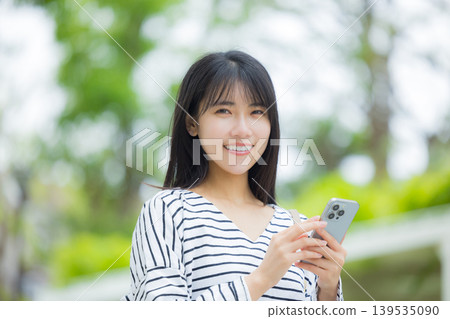 操作智能手機的一個少婦戶外 操作智能手機的一個少婦戶外 139535090