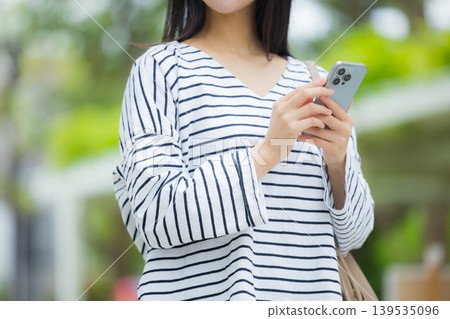 操作智能手機的一個少婦戶外 139535096