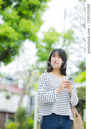 操作智能手機的一個少婦戶外 139535098