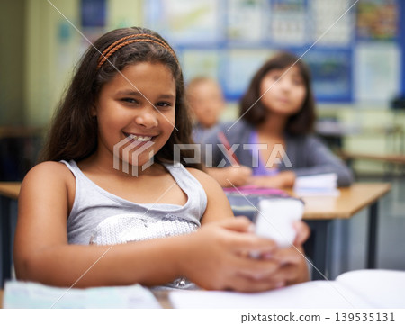 School, students or portrait of girl with phone for texting, gossip or message notification in classroom. News, sharing or happy child with a meme on mobile app or social media for online distraction 139535131