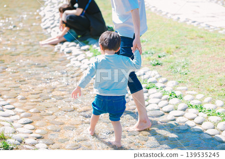 一位家長和孩子在夏日溪流中玩耍 一位家長和孩子在夏日溪流中玩耍 139535245
