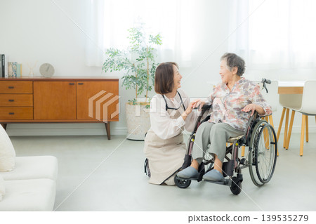 一位坐在輪椅上的老年婦女和一位正在照顧她的中年婦女。 139535279