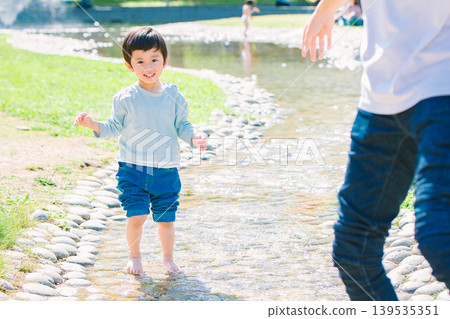 一位家長和孩子在夏日溪流中玩耍 139535351