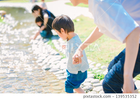 一位家長和孩子在夏日溪流中玩耍 139535352