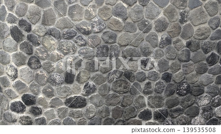 Stone wall texture with gray rocks, natural masonry pattern background, solid outdoor structure surface, detailed pebble arrangement under bright light, rural construction material backdrop. Stone wall texture with gray rocks, natural masonry pattern background, solid outdoor structure surface, detailed pebble arrangement under bright light, rural construction material backdrop. 139535508